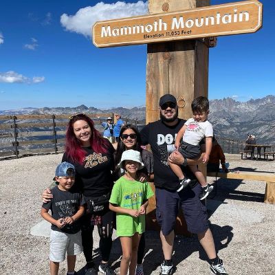The whole Campos family is posing for the picture with a huge Mammoth Mountain board in the background.